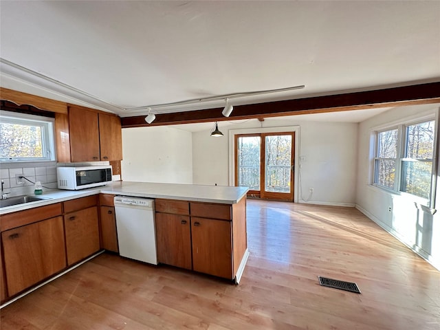 kitchen featuring kitchen peninsula, white appliances, and a wealth of natural light