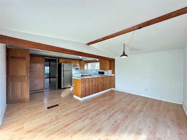 kitchen with lofted ceiling with beams, hanging light fixtures, light wood-type flooring, kitchen peninsula, and stainless steel refrigerator