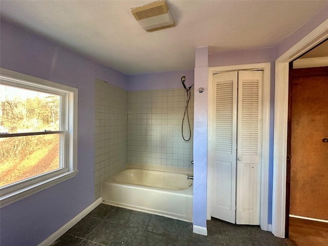 bathroom with tiled shower / bath combo and tile patterned floors