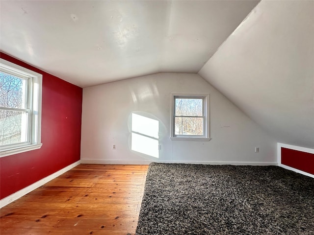 additional living space featuring hardwood / wood-style floors and vaulted ceiling