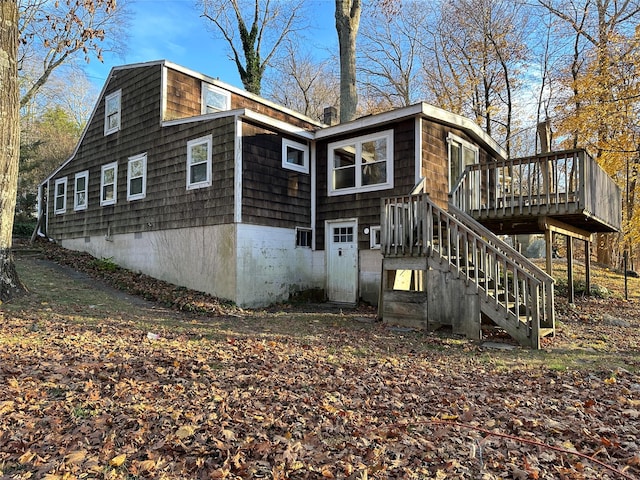 rear view of property featuring a wooden deck