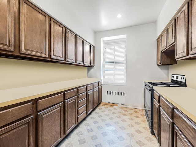 kitchen featuring radiator, electric range, and dark brown cabinetry