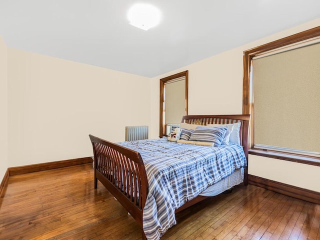 bedroom with radiator heating unit and dark wood-type flooring