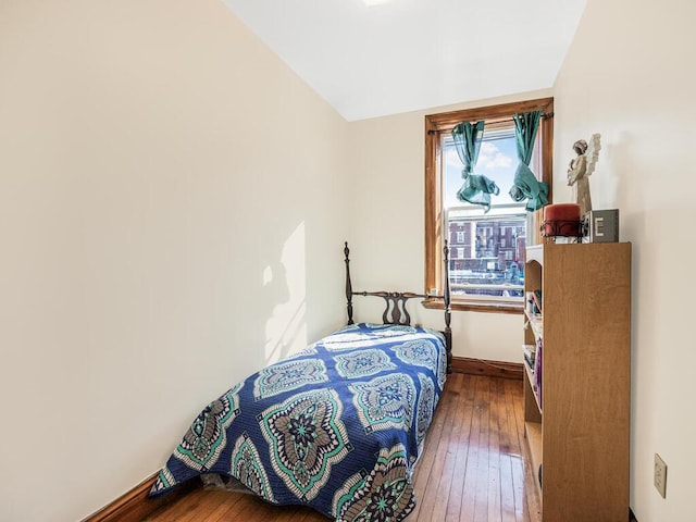 bedroom with hardwood / wood-style flooring and lofted ceiling