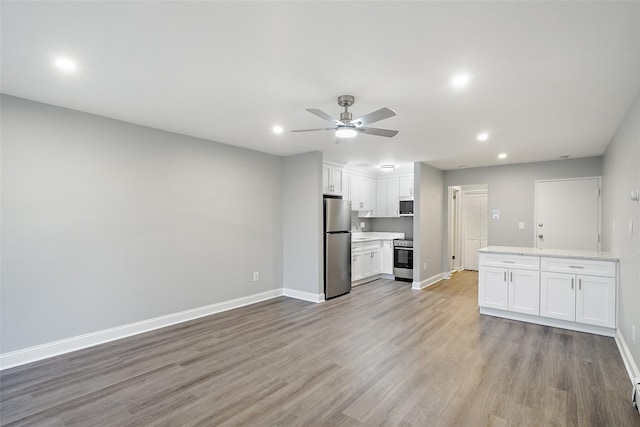 kitchen featuring white cabinets, sink, light hardwood / wood-style flooring, ceiling fan, and appliances with stainless steel finishes