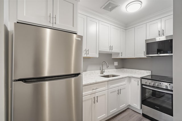 kitchen with appliances with stainless steel finishes, white cabinetry, and sink