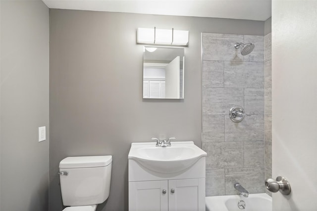 full bathroom with vanity, tiled shower / bath combo, and toilet