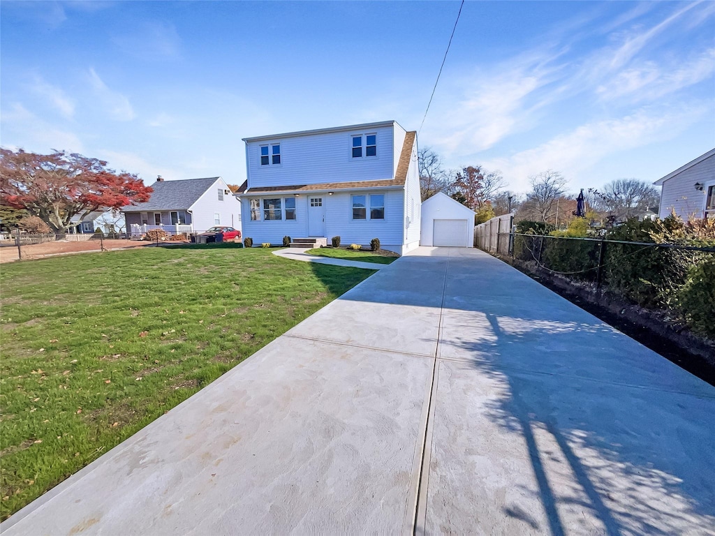 rear view of property featuring an outdoor structure, a garage, and a yard