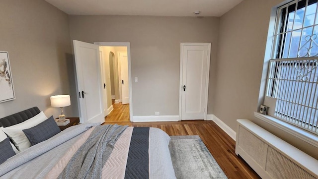 unfurnished bedroom featuring radiator and wood-type flooring