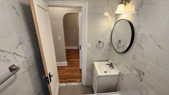 bathroom featuring hardwood / wood-style floors, vanity, and tile walls