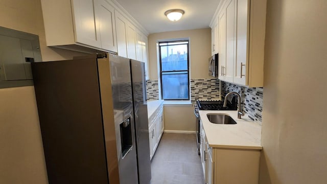 kitchen featuring backsplash, electric panel, white cabinets, sink, and stainless steel appliances