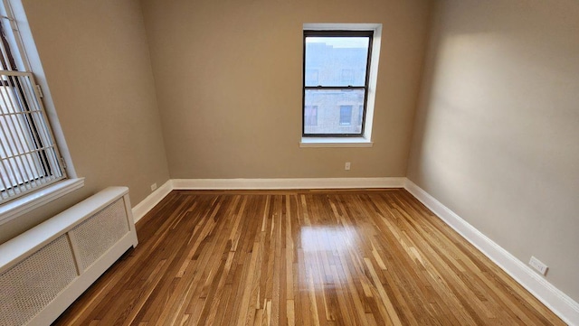 spare room with wood-type flooring and radiator