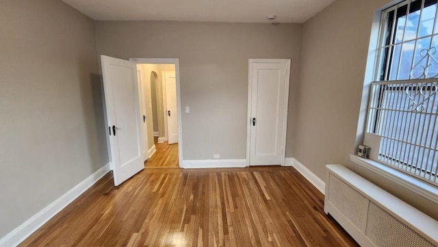 unfurnished room with light wood-type flooring and radiator