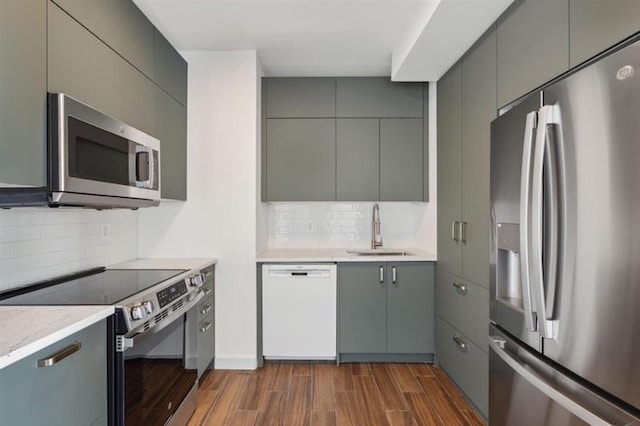 kitchen featuring dark hardwood / wood-style flooring, decorative backsplash, sink, and stainless steel appliances