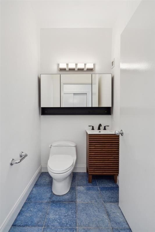 bathroom featuring tile patterned flooring, vanity, and toilet