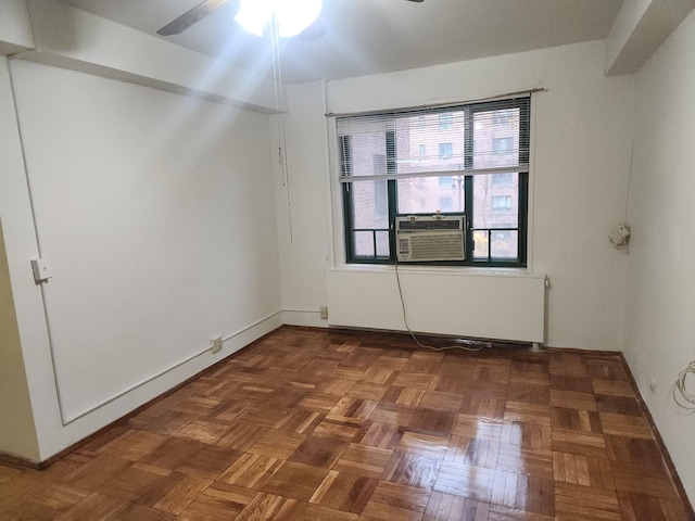 spare room with ceiling fan, cooling unit, and dark parquet floors