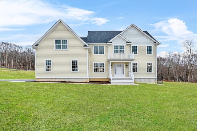 view of front of home with a balcony and a front lawn