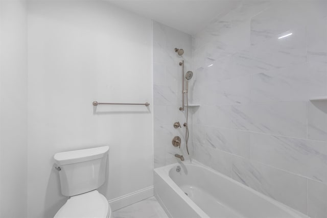 bathroom with toilet and tiled shower / bath