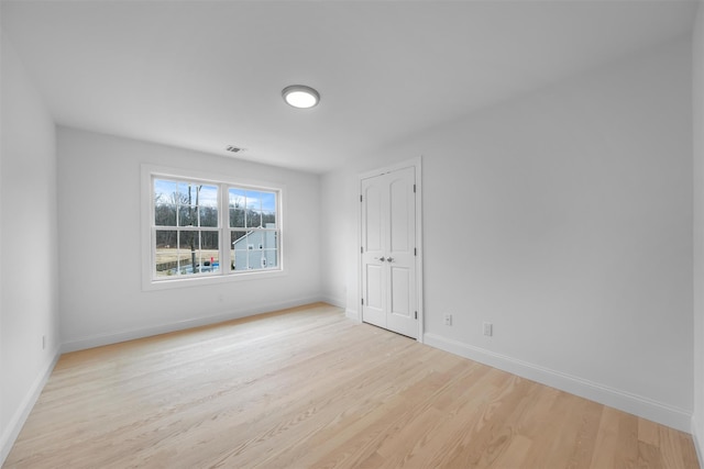 empty room with light hardwood / wood-style flooring