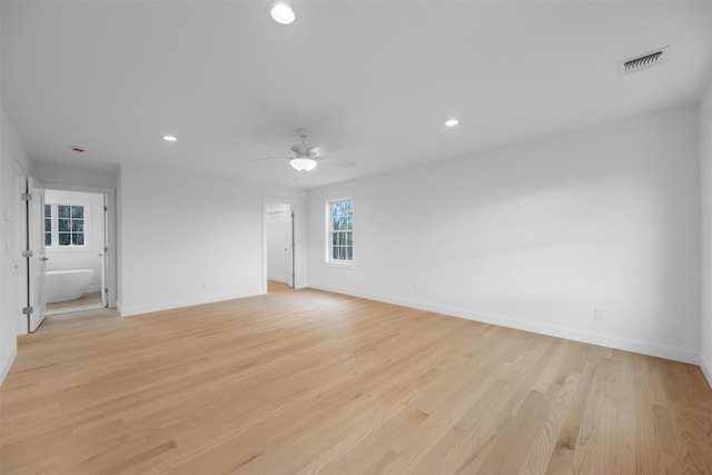 empty room with ceiling fan and light hardwood / wood-style floors