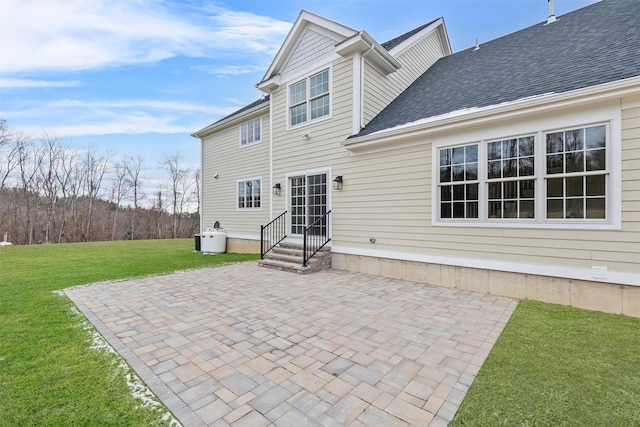 rear view of house featuring a lawn and a patio