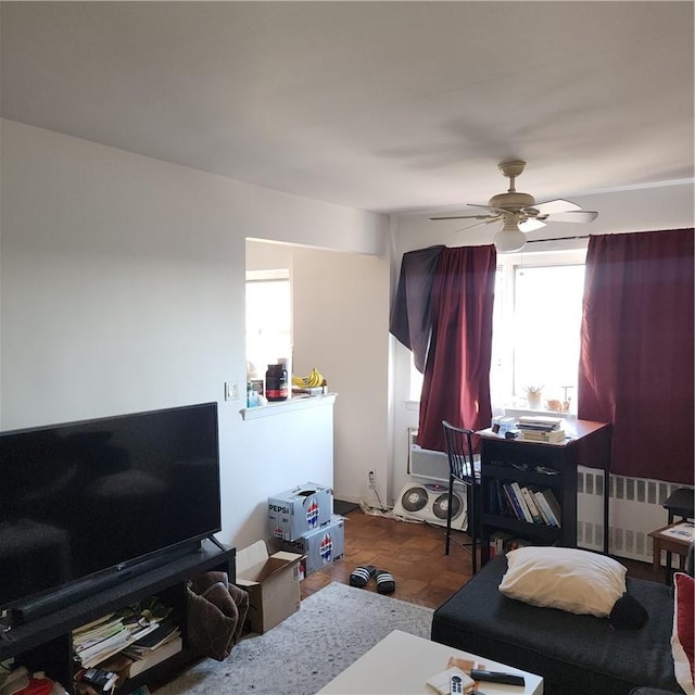 interior space with ceiling fan, radiator heating unit, and multiple windows