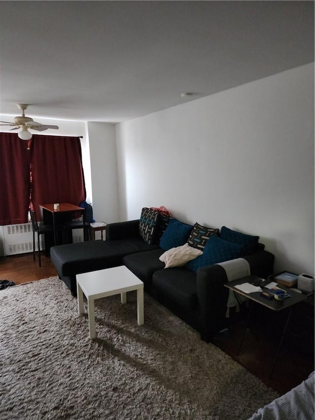 living room with radiator, ceiling fan, and wood-type flooring