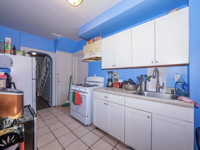 kitchen featuring white range with gas cooktop, white cabinetry, sink, and light tile patterned flooring