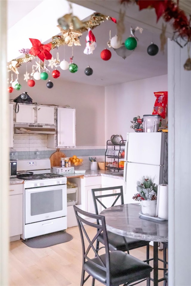 kitchen with light hardwood / wood-style floors, white appliances, decorative backsplash, white cabinets, and exhaust hood