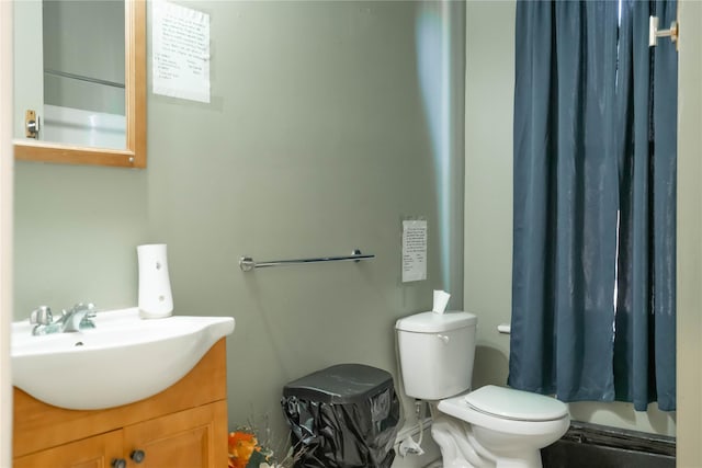 bathroom with curtained shower, vanity, and toilet