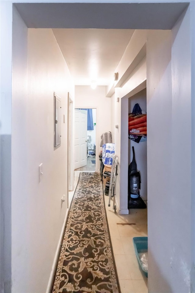 hall featuring electric panel and light tile patterned flooring