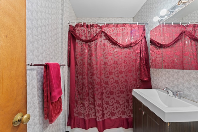 bathroom featuring vanity, walk in shower, and tile walls