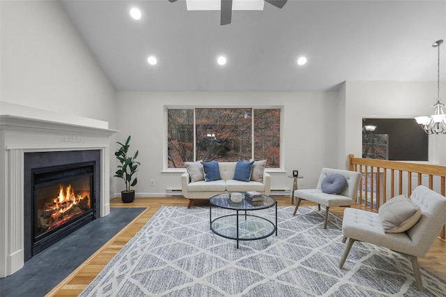 living room with ceiling fan with notable chandelier, hardwood / wood-style flooring, and a baseboard heating unit