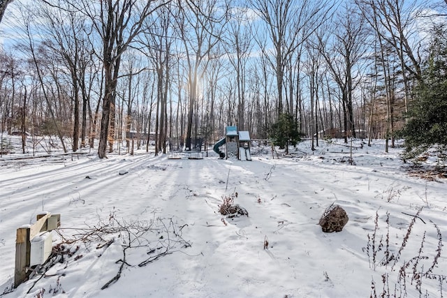 snowy yard featuring a playground