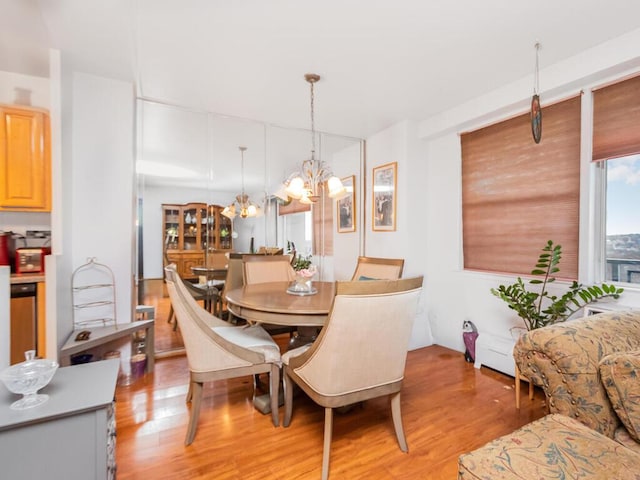 dining area with light hardwood / wood-style flooring and a notable chandelier