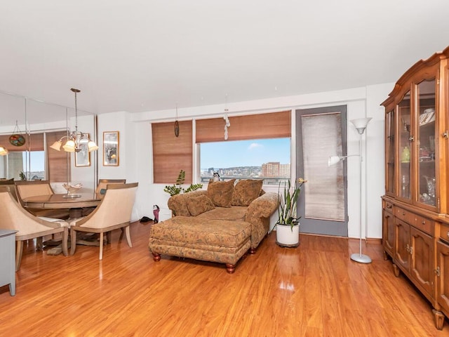 living room featuring light wood-type flooring and an inviting chandelier