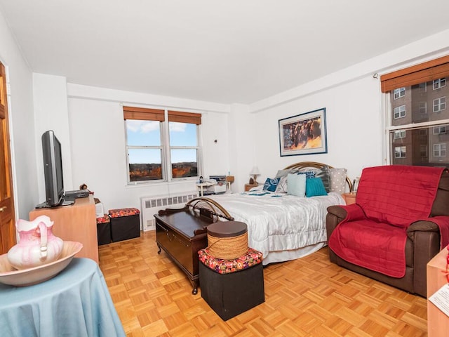 bedroom featuring light parquet floors and radiator