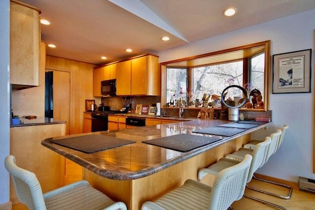 181 Starlight Rd, Monticello, NY 12701 - kitchen featuring a peninsula, dark countertops, a kitchen breakfast bar, recessed lighting, and black appliances