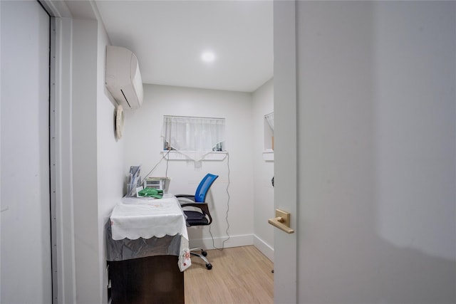 home office featuring light hardwood / wood-style floors and a wall mounted AC