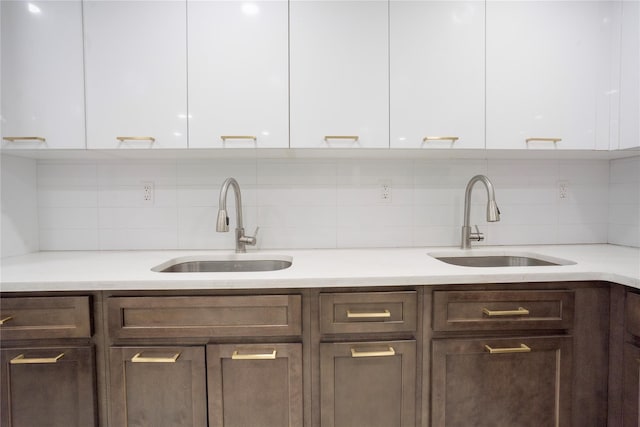 kitchen with white cabinetry, sink, and tasteful backsplash