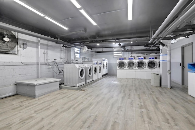 laundry area with separate washer and dryer and light hardwood / wood-style flooring