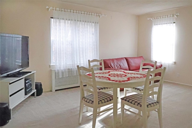 dining area featuring light carpet and a healthy amount of sunlight