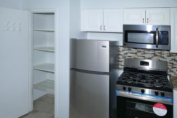 kitchen featuring white cabinetry, stainless steel appliances, and tasteful backsplash