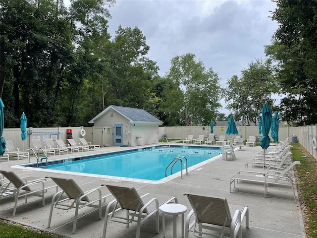 view of swimming pool featuring an outbuilding and a patio area