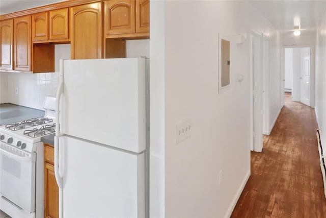 kitchen featuring dark hardwood / wood-style flooring, white appliances, tasteful backsplash, and electric panel