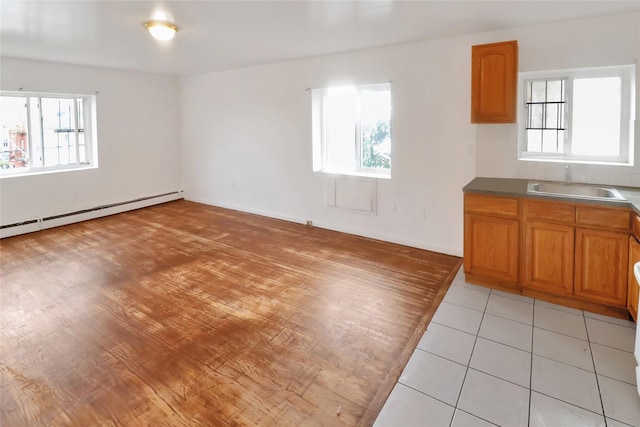 interior space featuring sink, a healthy amount of sunlight, and a baseboard heating unit