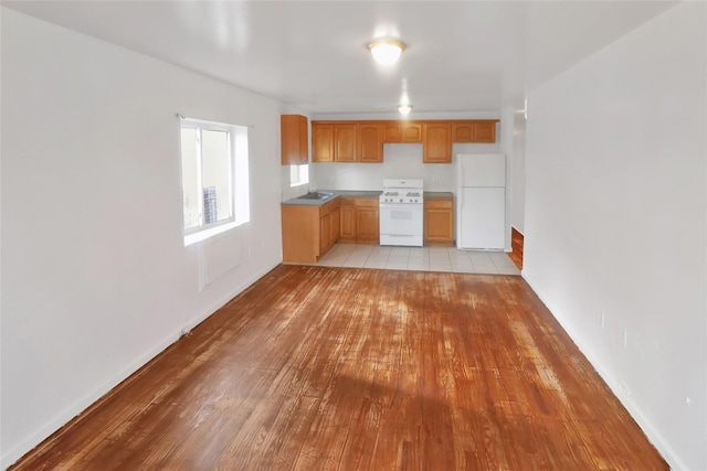 kitchen with sink, light hardwood / wood-style floors, and white appliances