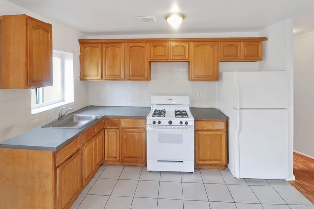 kitchen with white appliances, backsplash, light hardwood / wood-style flooring, and sink