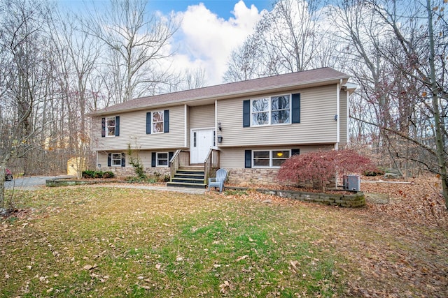 split foyer home featuring central air condition unit and a front lawn