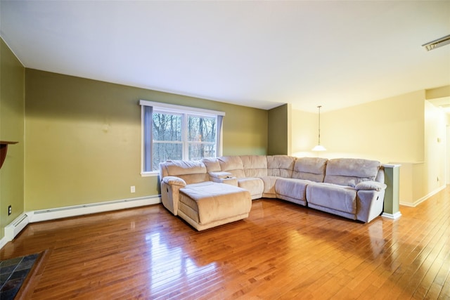 living room featuring hardwood / wood-style floors and a baseboard heating unit